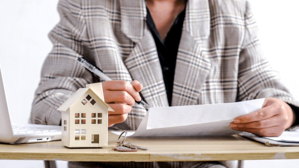 Unterlagen, Hausmodell und Schlüssel zur Berechnung der Immobilienertragsteuer in Österreich.
